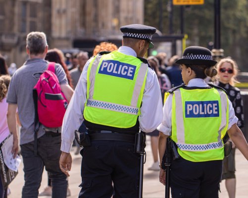 31st August, 2019 - Male and female Asian metropolitan police officers patrol the crowds of tourists outside the Hoses of Parliament in Westminster, London, UK