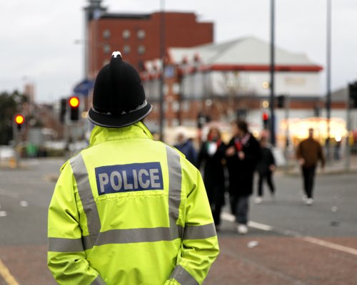 British Policeman Wearing Tradtional  Helmet Observes People-See below for more